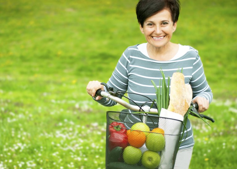 [Translate to Hungary - Hungarian:] Woman on a bike with healthy food in the basket