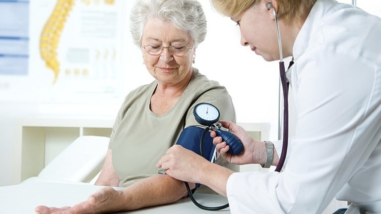 Orvos egy hölgy vérnyomását méri